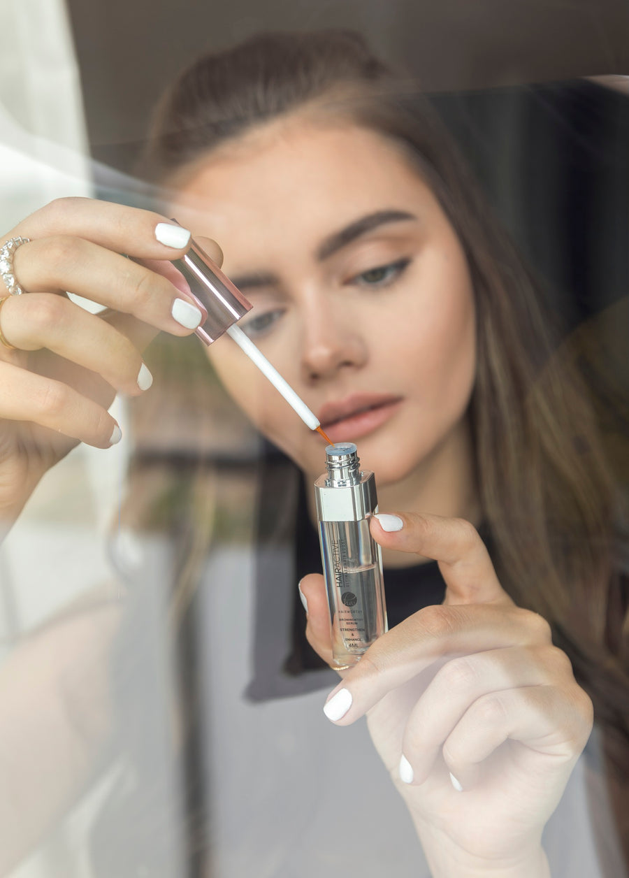 Close-up of a woman using the Everle brow serum applicator